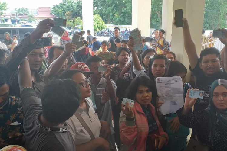 Ratusan warga Pekkanbaru yang tidak bisa ikut mencoblos memperlihatkan KTP mereka saat mendatangi Kantor KPU Pekanbaru, Rabu (17/4/2019). Warga protes tak bisa memilih karena kekurangan surat suara.