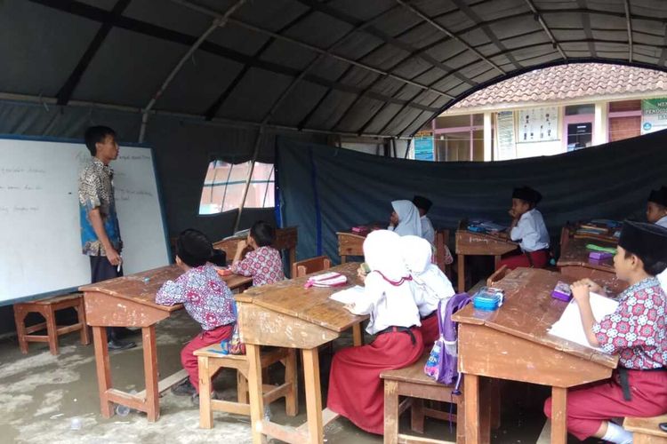 Puluhan siswa SDN 3 Cigorowong Kecamatan Cisayong Kabupaten Tasikmalaya terpaksa belajar di tenda darurat karena ruang kelasnya yang ditopang bambu rawan roboh dan berbahaya, Rabu (12/2/2020).