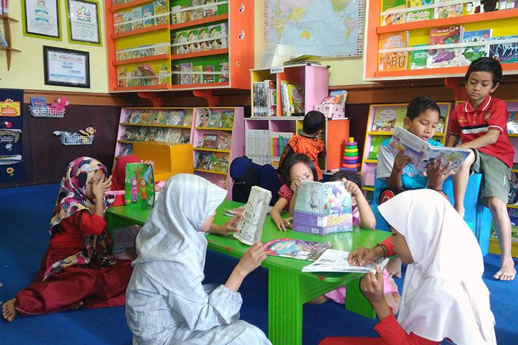 Anak-anak membaca di Taman Bacaan Masyarakat Rumah Pelangi di Desa Suci, Kecamatan Manyar, Gresik, Jawa Timur.