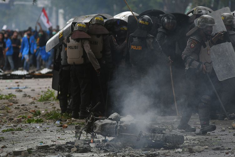 Sebuah motor polisi dirusak saat terjadinya kericuhan dalam aksi unjuk rasa mahasiswa yang menolak pengesahan RUU Cipta Kerja di Jalan Samratulangi Palu, Sulawesi Tengah, Kamis (8/10/2020). Aksi unjuk rasa oleh ribuan mahasiswa dari berbagai universitas di Kota Palu tersebut diwarnai kericuhan dan mengakibatkan sejumlah mahasiswa serta polisi terluka.