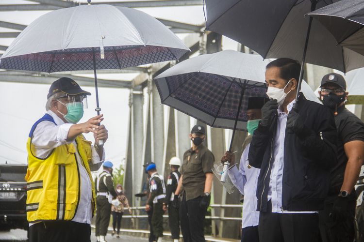 Presiden Joko Widodo (kanan) meninjau langsung lokasi banjir dari atas jembatan Pekauman didampingi Menteri PUPR Basuki Hadimuljono (kiri) di Desa Pekauman Ulu, Kabupaten banjar, Kalimantan Selatan, Senin (18/1/2021). Kunjungan kerja tersebut dalam rangka melihat langsung dampak banjir dan meninjau posko pengungsian korban banjir di Provinsi Kalimantan Selatan. ANTARA FOTO/Bayu Pratama S/aww. 