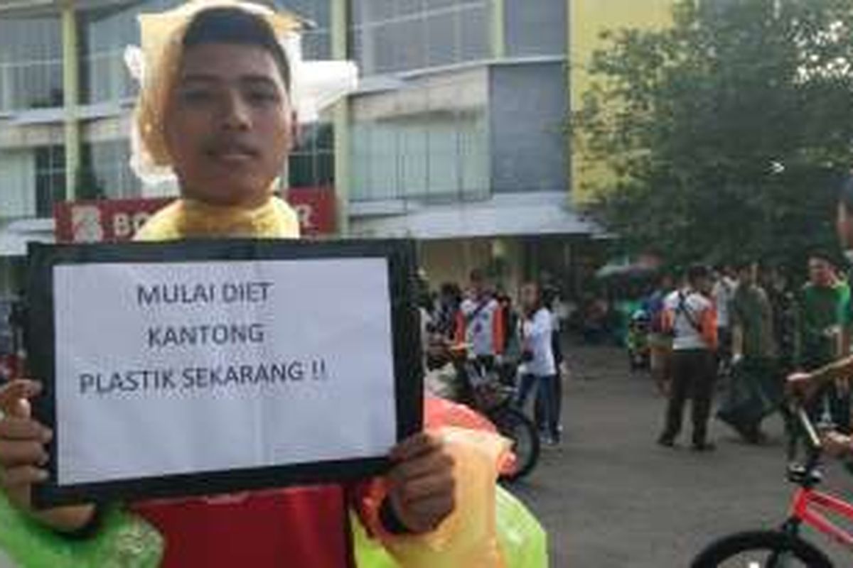 Guntur Prasetyo, siswa SMKN 1 Banyuwangi menggunakan pakaian kantong plastik dalam aksi pungut sampah pada Minggu (21/2/2016)