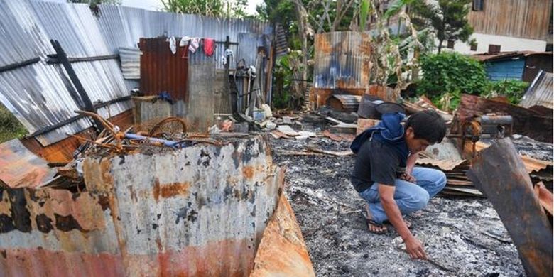 Seorang warga berada di puing rumahnya yang terbakar di kawasan Hom-hom, Kota Wamena, Kabupaten Jayawijaya, Papua, Sabtu (12/10). Kementerian Pekerjaan Umum dan Perumahan Rakyat (PUPR) menyatakan akan bekerja sama dengan Zeni TNI untuk segera membangun kembali kantor pemerintahan, perumahan, ruko, dan fasilitas umum yang rusak hingga terbakar pascaaksi unjuk rasa yang berujung anarkis pada 23 September 2019. 