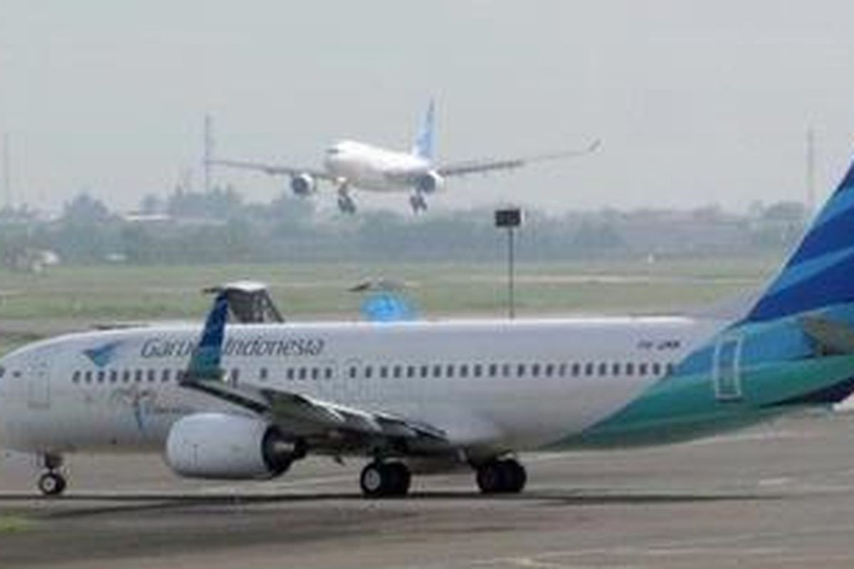 This photograph taken on October 26, 2010, an Indonesian Garuda Airline plane lands and another prepares to take off at Soekarno-Hatta airport in Jakarta.
