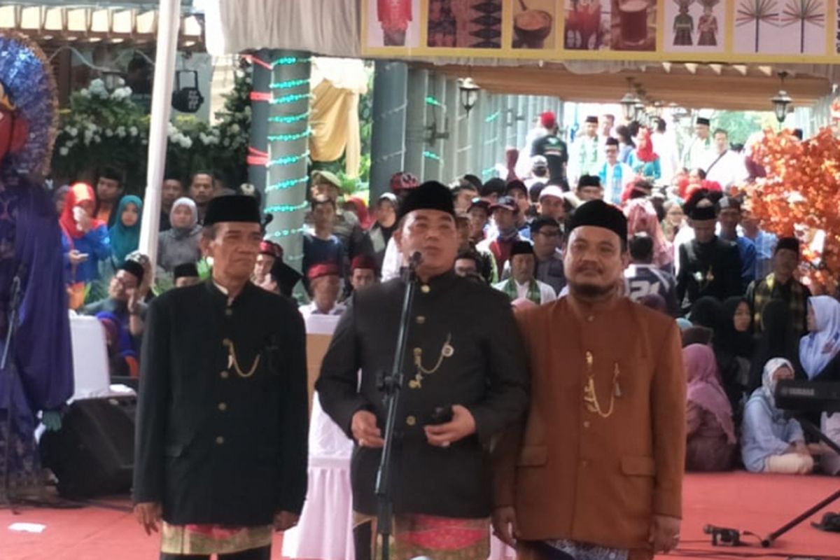 Ketua Panitia Lebaran Betawi Munier Arsyad (tengah) saat memberikan sambutan di depan Gubernur DKI Jakarta Anies Baswedan dalam Lebaran Betawi yang digelar di Perkampungan Budaya Betawi Setu Babakan, Jagakarsa, Jakarta Selatan, Minggu (29/7/2018).