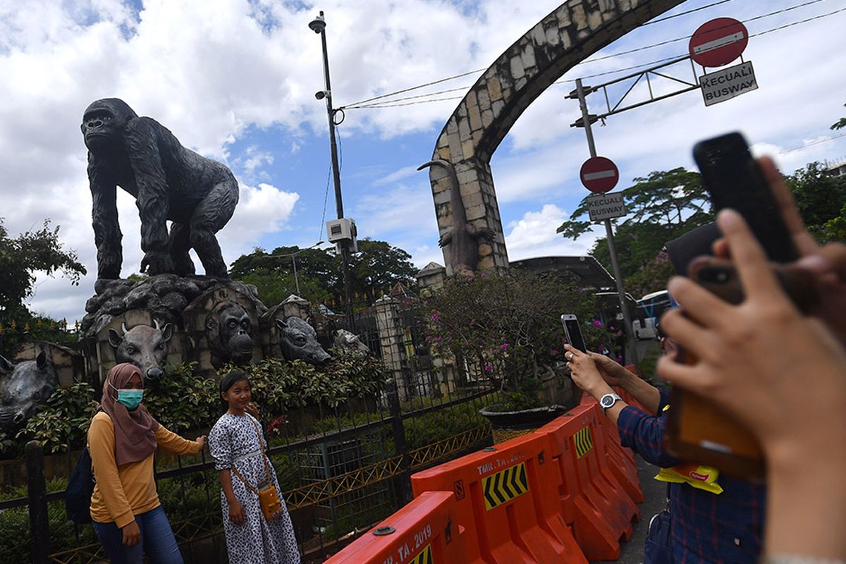 Warga berfoto di kawasan Taman Margasatwa Ragunan, Jakarta Selatan, Jumat (25/12/2020). Pemerintah Provinsi DKI Jakarta menutup area publik dan sejumlah tempat wisata termasuk Taman Margasatwa Ragunan selama masa libur perayaan Hari Natal dan Tahun Baru pada 25 dan 31 Desember 2020, serta 1 Januari 2021.