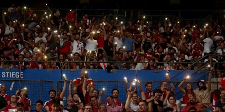 Fan yang menghadiri laga UEFA Nations League 2022-2023 Austria vs Denmark menyalakan ponsel untuk menerangi Stadion Ernst-Happel, pada 6 Juni 2022. Laga Austria vs Denmark sempat tertunda gara-gara Stadion Ernst-Happel mati lampu.