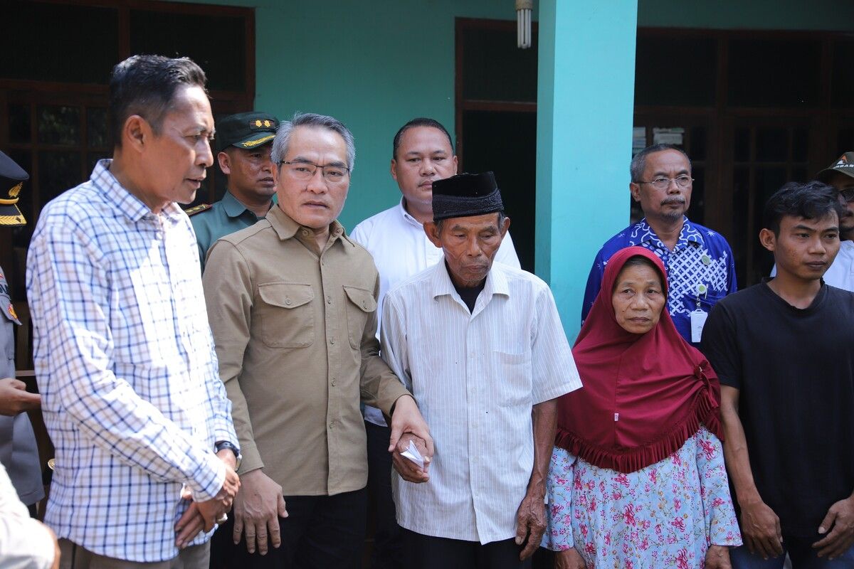 Bupati Bantul Abdul Halim Muslih (baju coklat) menggandeng Mbah Tupon di Kasihan, Bantul. Jumat (9/5/2025)