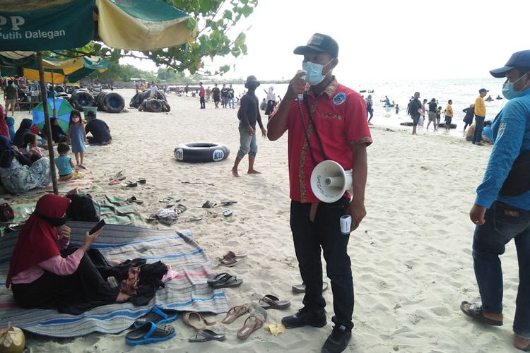 Petugas terus mengingatkan para pengunjung wisata pasir putih Dalegan untuk menerapkan protokol kesehatan.