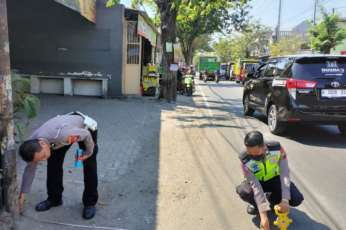 Pihak kepolisian saat melakukan olah TKP usai kecelakaan lalu lintas di Jalan Raya Desa Domas, Kecamatan Menganti, Gresik, Jawa Timur, Selasa (30/7/2024).