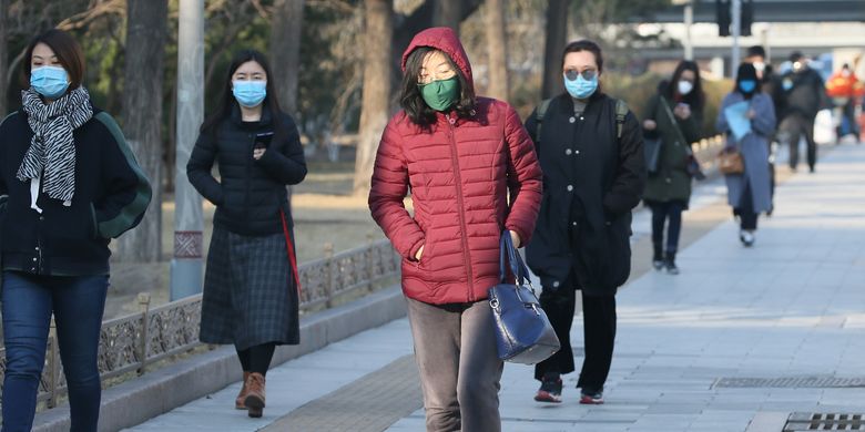 Orang-orang tetap melanjutkan aktivitas di Beijing, China, pada Kamis (5/3/2020), di tengah wabah virus corona yang melanda negara tersebut.