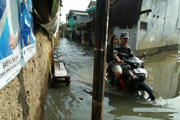 Tampak warga tengah mengendarai motor menembus banjir yang menggenangi salah satu wilayah di Kabupaten Bandung.