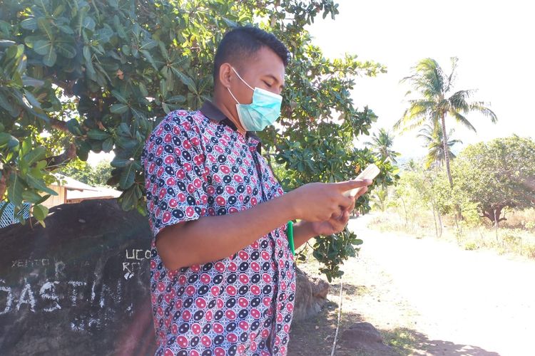 Foto : Anjelus Nartinus, salah satu petugas UPTD puskemas Mapitara, Kecamatan Mapitara, Kabupaten Sikka, NTT, sedang mencari sinyal di titik batu besar mencari sinyal, Senin (27/7/2020). 