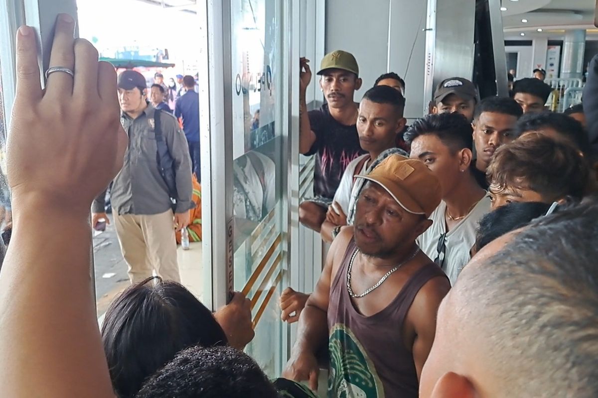 Penumpang KM Umsini saat mendesak untuk naik ke atas kapal mengambil barang bawaan mereka yang tertinggal akibat kebakaran di Pelabuhan Soekarno Hatta Makassar, Sulsel, Minggu (9/6/2024)