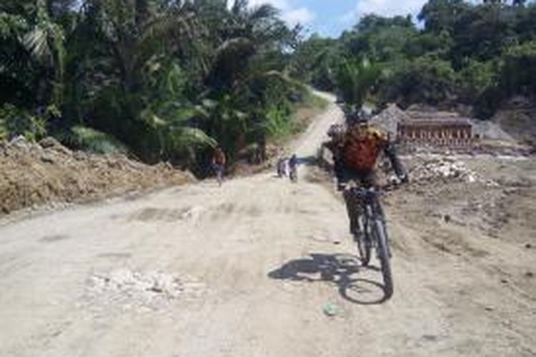 Pesepeda melintasi jalan rusak sekaligus menanjak pada etape 2 Jelajah Sepeda Papua, Kamais (4/6/2015).