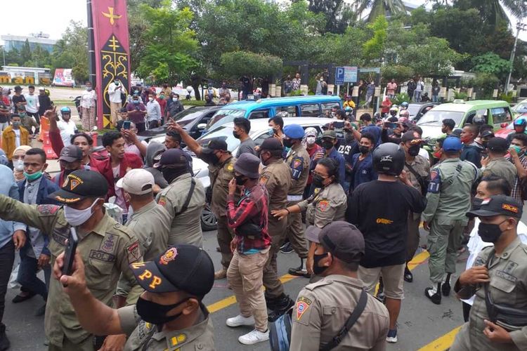 Aksi unjuk rasamenolak pemberlakuan pembtasan kegiatan masyarakat (PPKM) mikro di depan Kantor Wali Kota Kota Ambon berlangsung bentrok antara petugas dan mahasiswa, Selasa (27/7/2021)