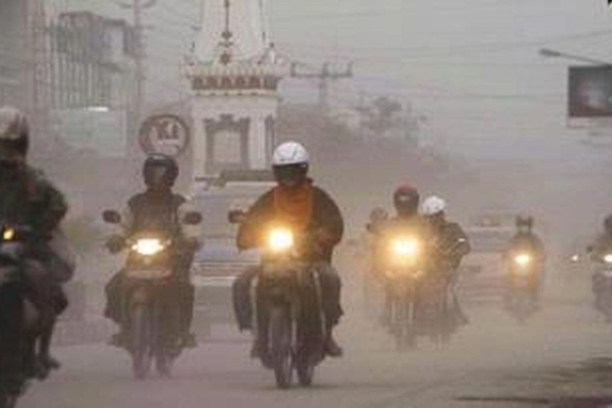 Warga melintasi di kawasan Tugu yang diselimuti abu vulkanik akibat letusan Gunung Merapi di Jalan Sudirman, Yogyakarta, Sabtu (30/10/2010). Debu letusan ini menyebabkan sejumlah penerbangan dari dan ke Yogyakarta terganggu. Pemberangkatan dan pendaratan dialihkan ke Bandara Adisumarmo, Solo. 