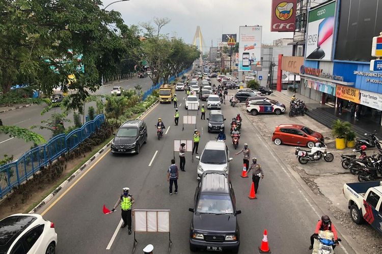 Petugas Satlantas Polresta Pekanbaru melakukan pemeriksaan terhadap pengendara di Jalan Jenderal Sudirman untuk mencegah Covid-19 sebelum diterapkan PSBB di Kota Pekanbaru, Riau, Kamis (16/4/2020).