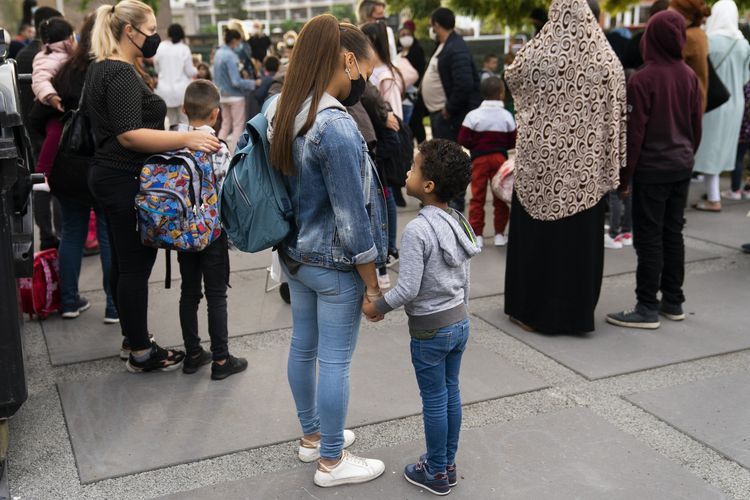 Anak-anak dan para orangtua memakai masker di hari pertama pembukaan kembali sekolah di Brussels, Belgia, pada Selasa (1/9/2020).