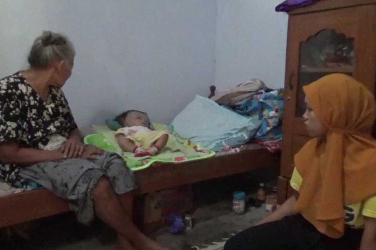 HIDROSEFALUS—Nur Hidayah (23), warga Desa Ketandan, Kecamatan Dagangan, Kabupaten Madiun, Jawa Timur menatap Gibran (7 bulan), anaknya yang menderita penyakit hidrosifalus.