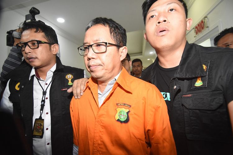 Mantan Plt Ketua Umum PSSI Joko Driyono (tengah) mengenakan rompi tahanan seusai menjalani pemeriksaan di Ditreskrimum Polda Metro Jaya, Jakarta, Selasa (26/3/2019) dinihari. Satgas Anti  Mafia Bola Polri menahan Joko Driyono terkait kasus dugaan pengaturan skor pertandingan bola Liga 2 dan Liga 3. ANTARA FOTO/Indrianto Eko Suwarso/pd.