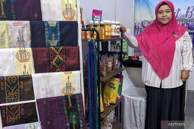 Pembina Industri Dinas Perindustrian dan Perdagangan (Disperindag) Tapanuli Tengah Riza Erliana memperlihatkan beberapa produk UMKM wilayahnya di Kodam I Bukit Barisan Expo 2023, Lapangan Benteng, Medan, Rabu (19/7/2023). () 
