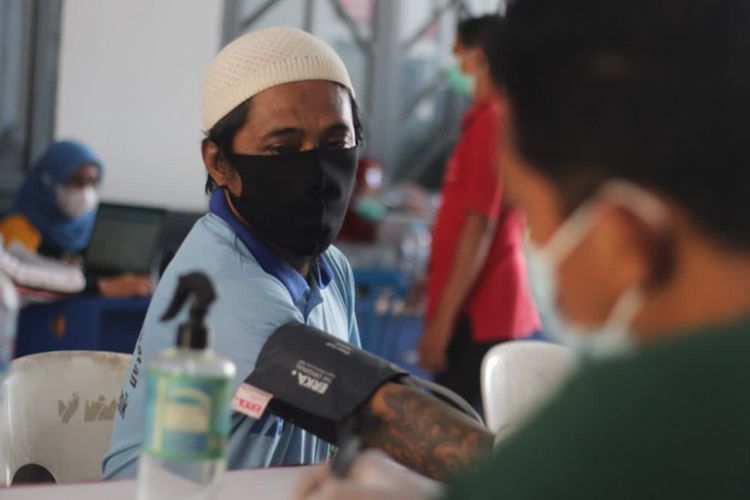 Salah seorang warga binaan menjalani proses skrining sebelum mengikuti vaksinasi dosis kedua di Rutan Klas IIB Gresik, Jumat (22/10/2021).