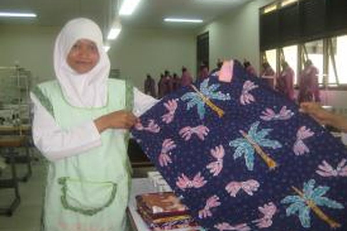 Nurul, siswi kelas X Sekolah Menengah Kejuruan Negeri (SMKN) 2 Gedangsari, Kabupaten Gunung Kidul, Yogyakarta memamerkan batik tulis bermotif pisang (gedang). 