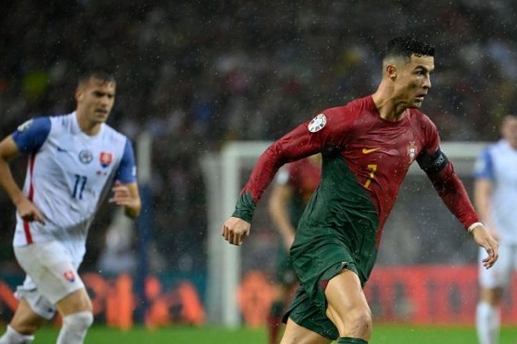 Penyerang sekaligus kapten timnas Portugal, Cristiano Ronaldo (kanan), menggiring bola dalam laga Kualifikasi Euro 2024 melawan Slovakia di Stadion Dragao, Porto, pada Jumat (13/10/2023).