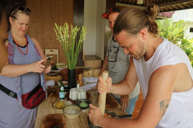 Wisatawan mancanegara mencoba memasak makanan bali di Ubud. 