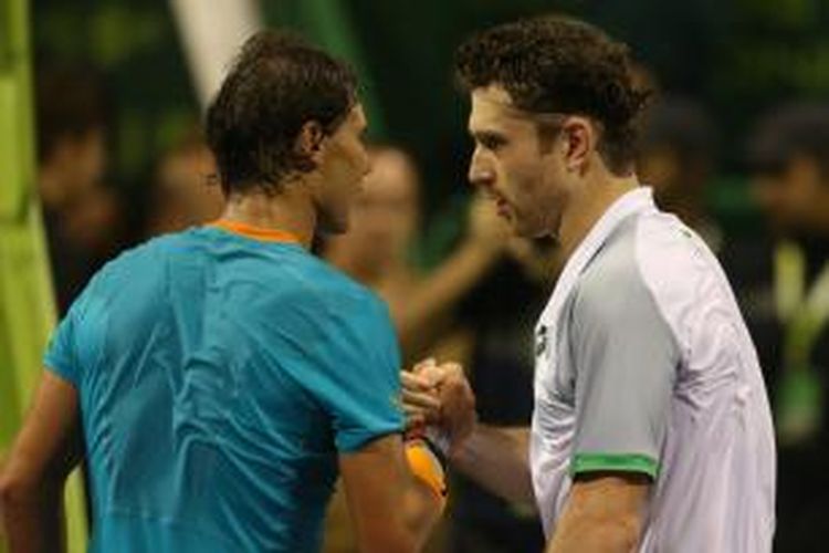 Petenis Spanyol, Rafael Nadal (kiri), bersalaman dengan petenis Jerman, Michael Berrer, setelah pertandingan babak pertama turnamen Qatar Terbuka di Doha, Selasa (6/1/2015). Nadal kalah 6-1, 3-6, 4-6.