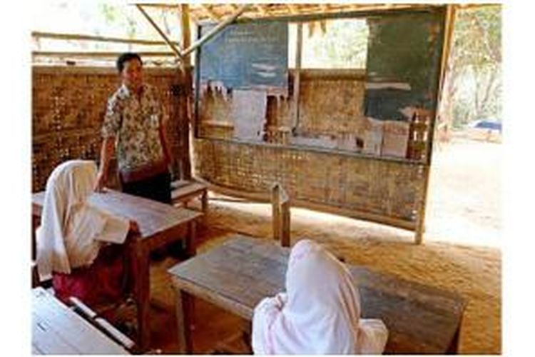 Haitami (43), guru kelas Sekolah Dasar Negeri Cijaralang 2, berbincang dengan beberapa muridnya di sela-sela pelajaran tambahan, di Desa Cijaralang, Kecamatan Cimanggu, Kabupaten Pandeglang, Banten, pertengahan Oktober 2014.