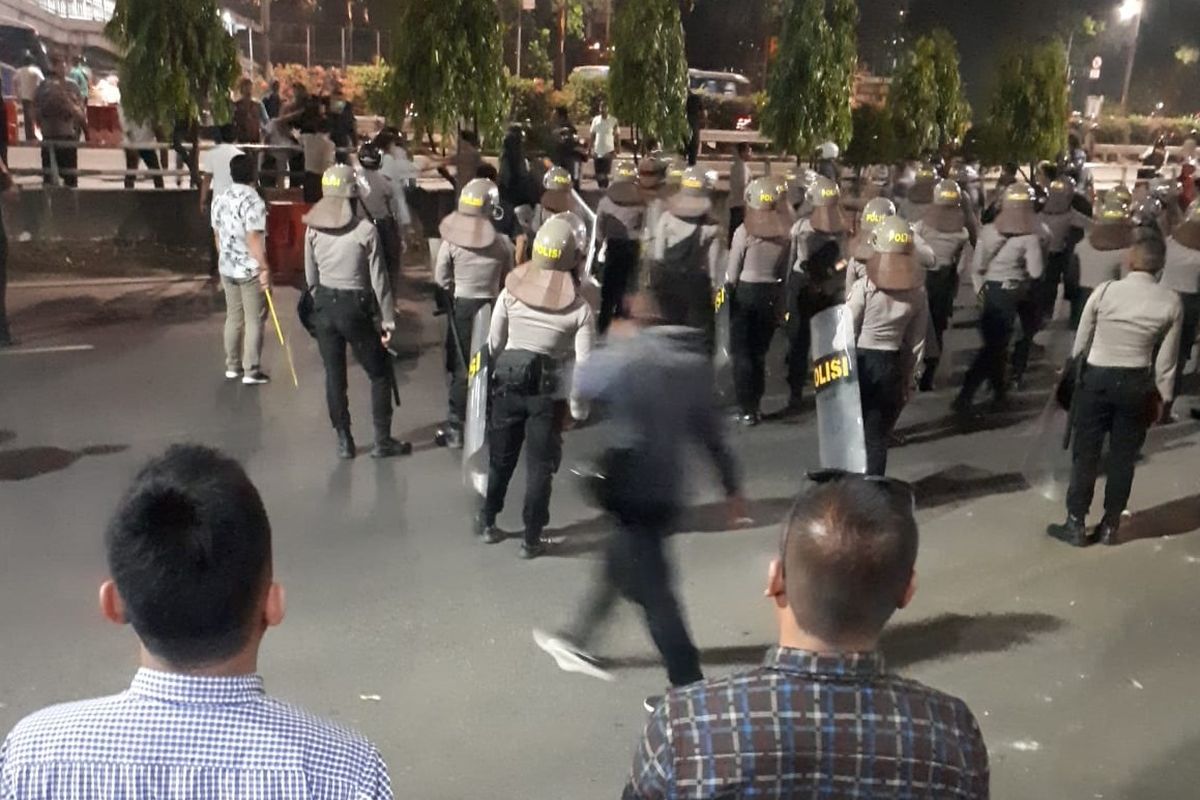 Polisi mengejar satu orang pemuda yang diduga menyebabkan kerusuhan saat demo mahasiswa dan pelajar di Jalan Gatot Subroto, Jakarta Selatan tepatnya di depan gedung Polda Metro Jaya, Jakarta Selatan, Senin (30/9/2019)