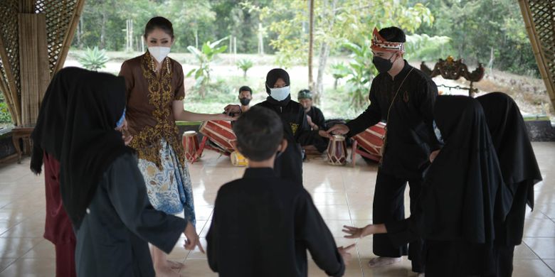Para wisatawan sedang mencoba permainan tradisional di Alamendah, Kabupaten Bandung.
