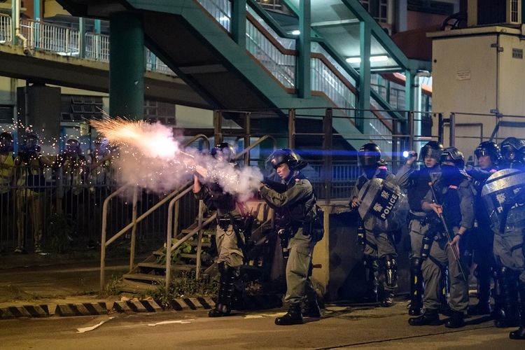 Petugas polisi anti-huru hara menembakkan gas air mata ke arah demonstran dalam aksi protes di Hong Kong, Senin (21/10/2019).