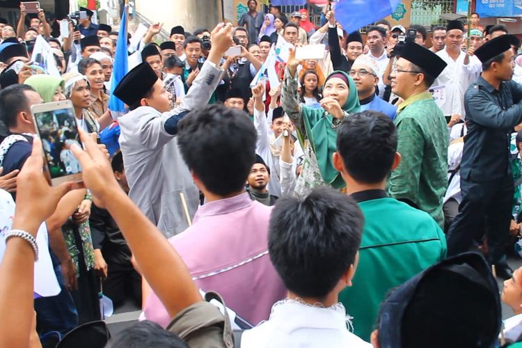 Paslon Zulkieflimansyah dan Siti Rihmi Djalilah (hijau) tengah selfie di tengah massa pendukungnya seusai mendaftar di KPUD NTB, Rabu (10/1/2018).