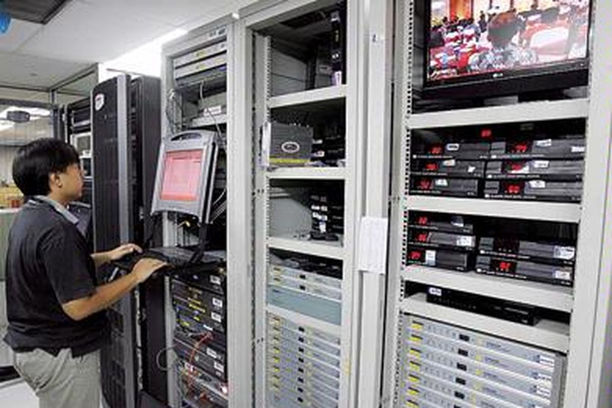 Petugas teknologi informasi   mengecek jaringan   server (pusat data) pada sistem komputasi konvensional. Pada sistem komputasi awan, pengguna tak perlu menyediakan perangkat keras, cukup menyewa layanan lewat internet.