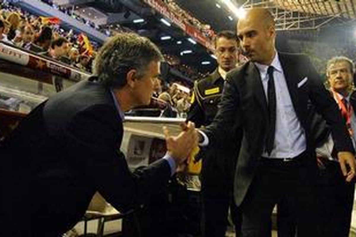 Manajer Real Madrid Jose Mourinho (kiri) berjabat tangan dengan pelatih Barcelona Josep "Pep" Guardiola sesaat sebelum anak-anak didik mereka melakoni duel final Copa del Rey, di Mestalla, Rabu (20/4/2011).