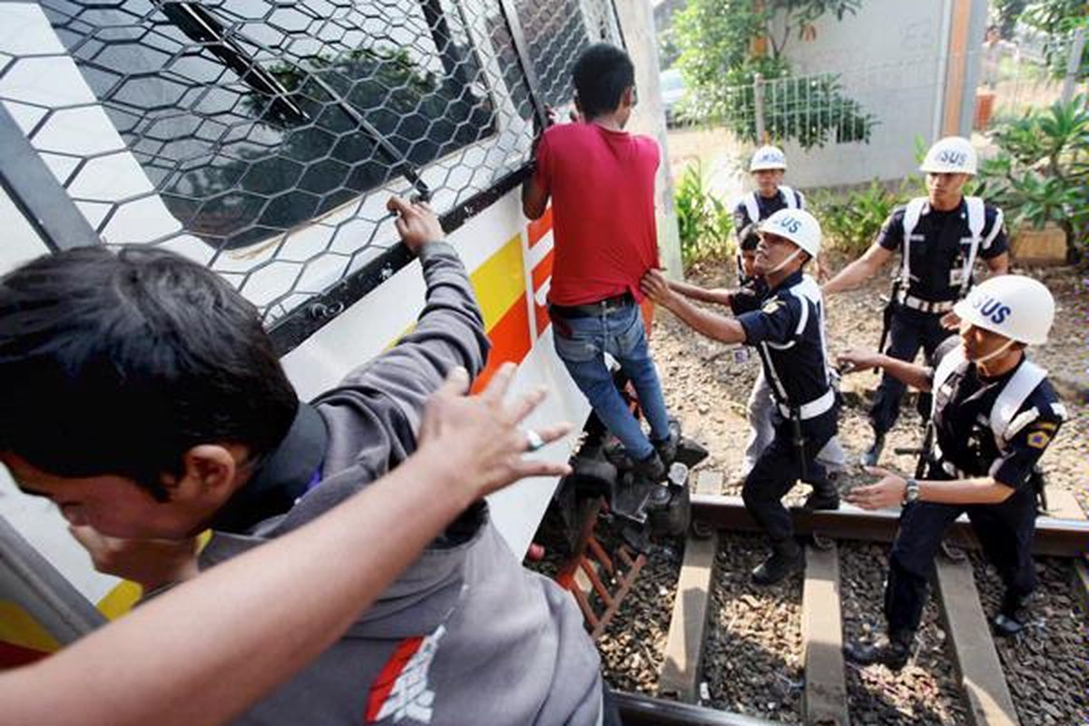 Petugas Polisi Khusus Kereta Api menangkap penumpang  ekonomi jurusan Bogor-Jakarta yang berdiri di lokomotif saat penertiban penumpang di Stasiun Pasar Minggu, Jakarta Selatan, Selasa (10/5). Penertiban itu bertujuan untuk meningkatkan keselamatan perjalanan kereta api. Selain diturunkan, penumpang yang terjaring langsung disidang di tempat.