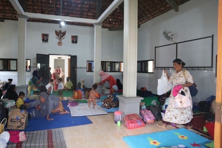 Warga Desa Gondangmanis, Kecamatan Bandar Kedungmulyo, Kabupaten Jombang, Jawa Timur, mengungsi ke kantor desa karena banjir yang melanda tempat tinggal mereka, Jumat (5/2/2021).