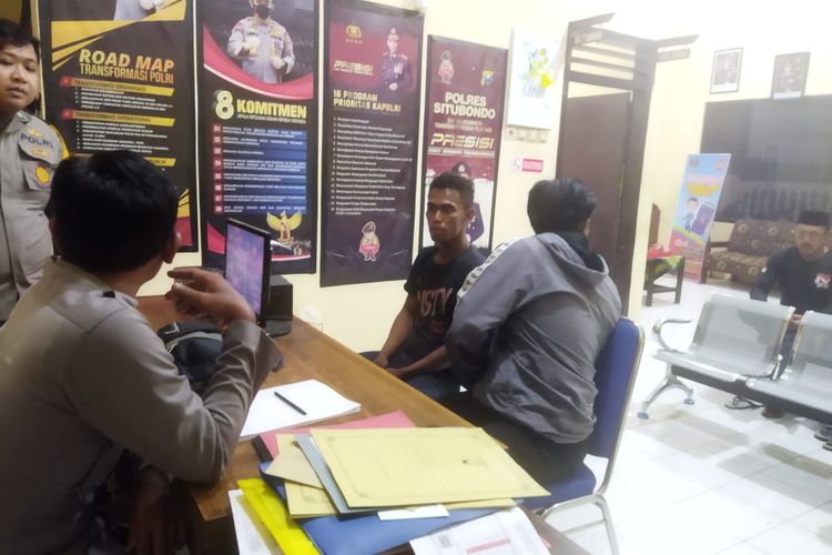 DS (baju hitam) sedang duduk di depan monitor Polsek Banyuputih Polres Situbondo ketika diamankan pada Senin (7/11/2023) oleh warga dan polisi..