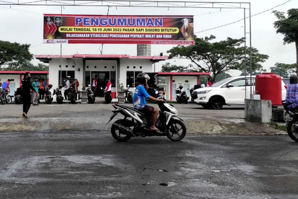 Sebuah banner berisi informasi penutupan sementara Pasar Hewan Dimoro, Kota Blitar dibentangkan di atas kantor pasar, Jumat (10/6/2022)