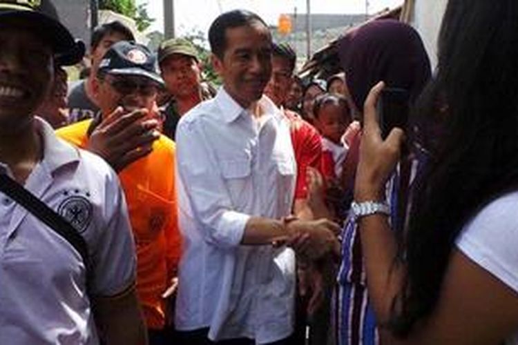 Gubernur DKI Jakarta Joko Widodo meninjau kerja bakti antara warga, relawan Jakarta Bersih, dan Satuan Kerja Perangkat Daerah (SKPD) terkait,  di Lagoa,  Jakarta Utara,  Minggu (3/2/2013). Di sana,  ia memberikan bantuan berupa beras,  buku tulis, dan seragam kepada warga Lagoa.