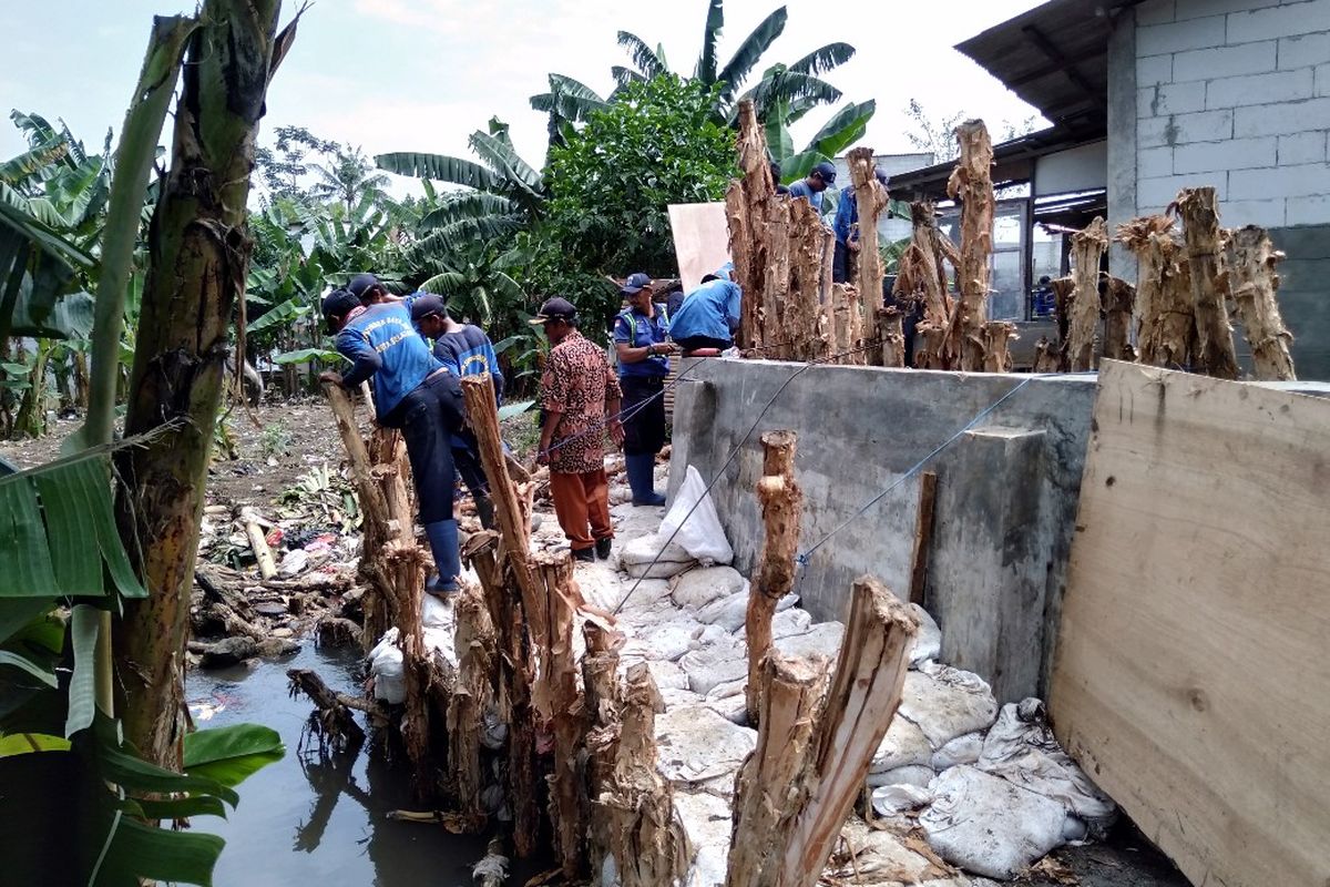 Para Petugas Suku Dinas Tata Air sedang memperbaiki tanggul Jatipadang, Kamis (4/4/2019).