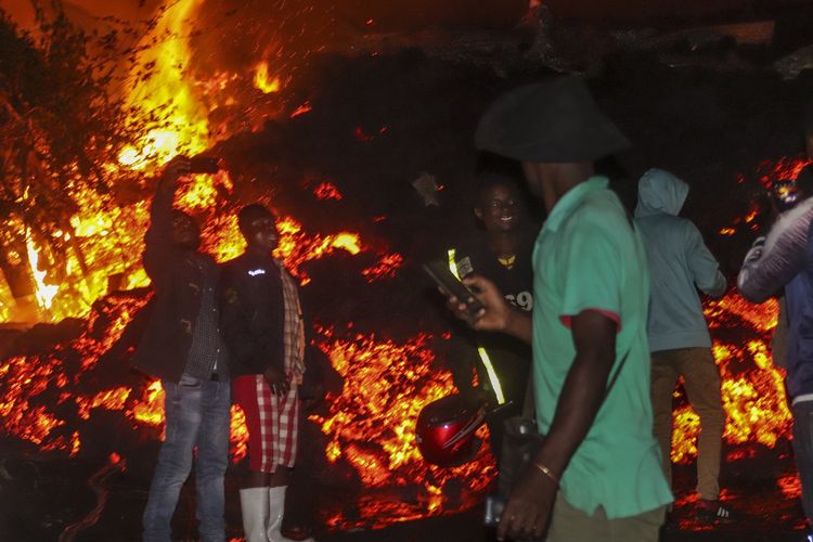 Warga berdiri dan melakukan selfie di depan lava dari erupsi Gunung Nyiragongo di Buhene, luar Goma, Republik Demokratik Kongo, pada 23 Mei 2021.