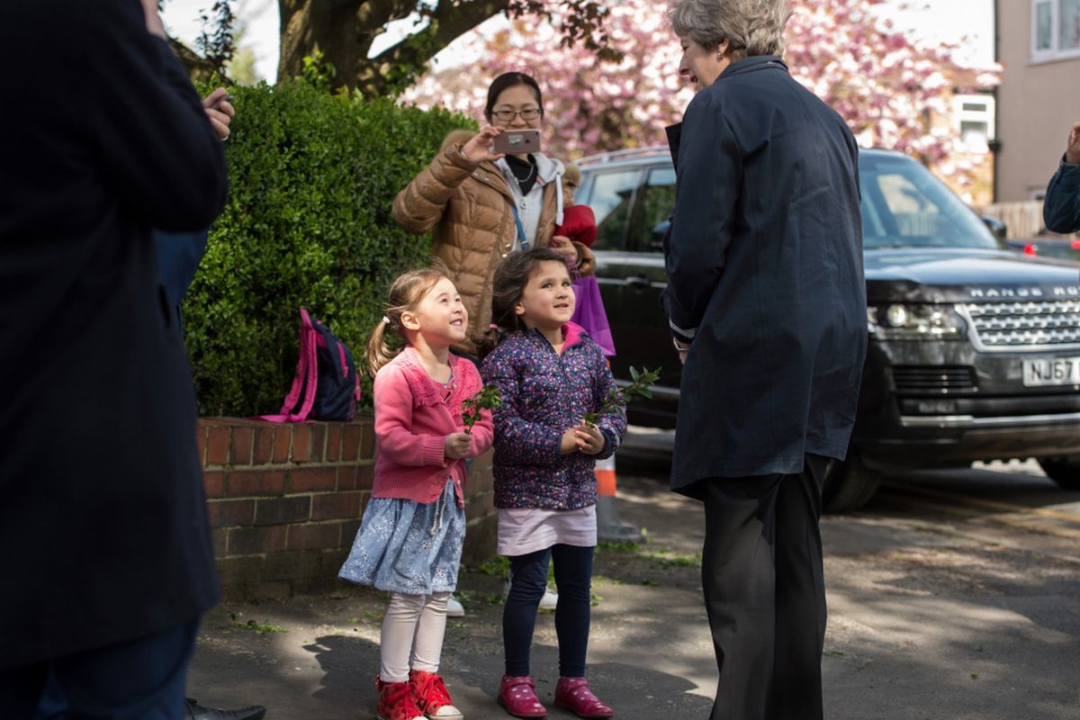 Perdana Menteri Inggris Theresa May (tengah) berbicara dengan warga saat ia pergi setelah mengunjungi Sekolah Dasar Brooklands di Sale, dekat Manchester, Inggris bagian utara, 30 April 2018, sebagai bagian dari kampanye pemilihan lokal Partai Konservatif.