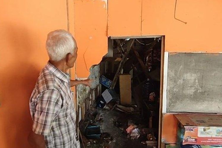 Saat Kusnadi dan warga lainnya memperlihatkan warung yang rusak tertabrak motor 
