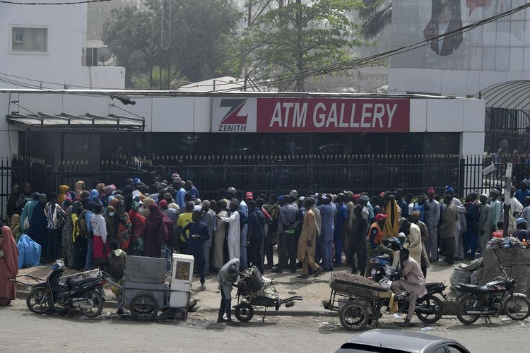 Puluhan orang mengantre untuk menarik uang dari ATM di Kano, Nigeria, 8 Februari 2023, saat negara itu mengalami krisis uang tunai. Peristiwa ini dipicu oleh pergantian uang kertas mendadak menjelang pemilihan presiden.