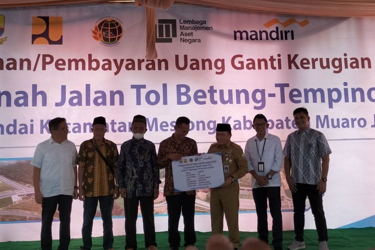 Tiga warga Desa Sungai Landai Kabupaten Muaro Jambi secara simbolik terima uang ganti rugi pembebasan lahan pembangunan Tol Jambi Betung, pada Senin (14/11/2022). 