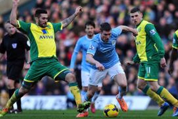 Gelandang Manchester City James Milner (kedua dari kanan) berebut bola dengan gelandang Norwich City Bradley Johnson (kiri), pada laga Premier League, di Carrow Road, Sabtu (8/2/2014).